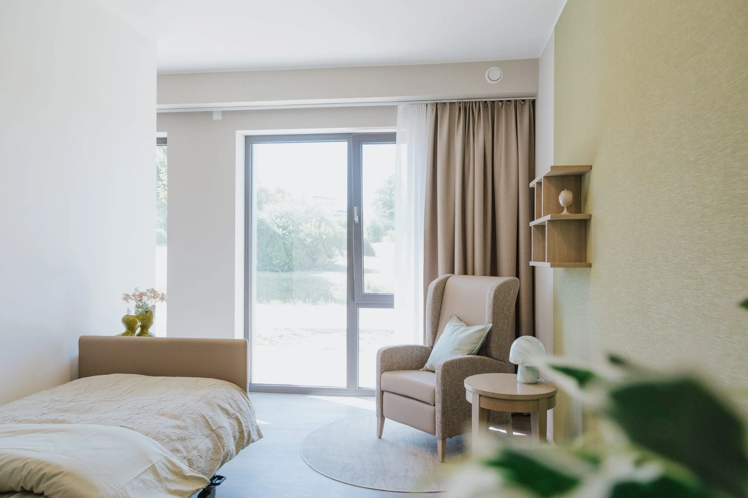 Apartment mit Pflegebett und Sitzbereich im betreuten Wohnen