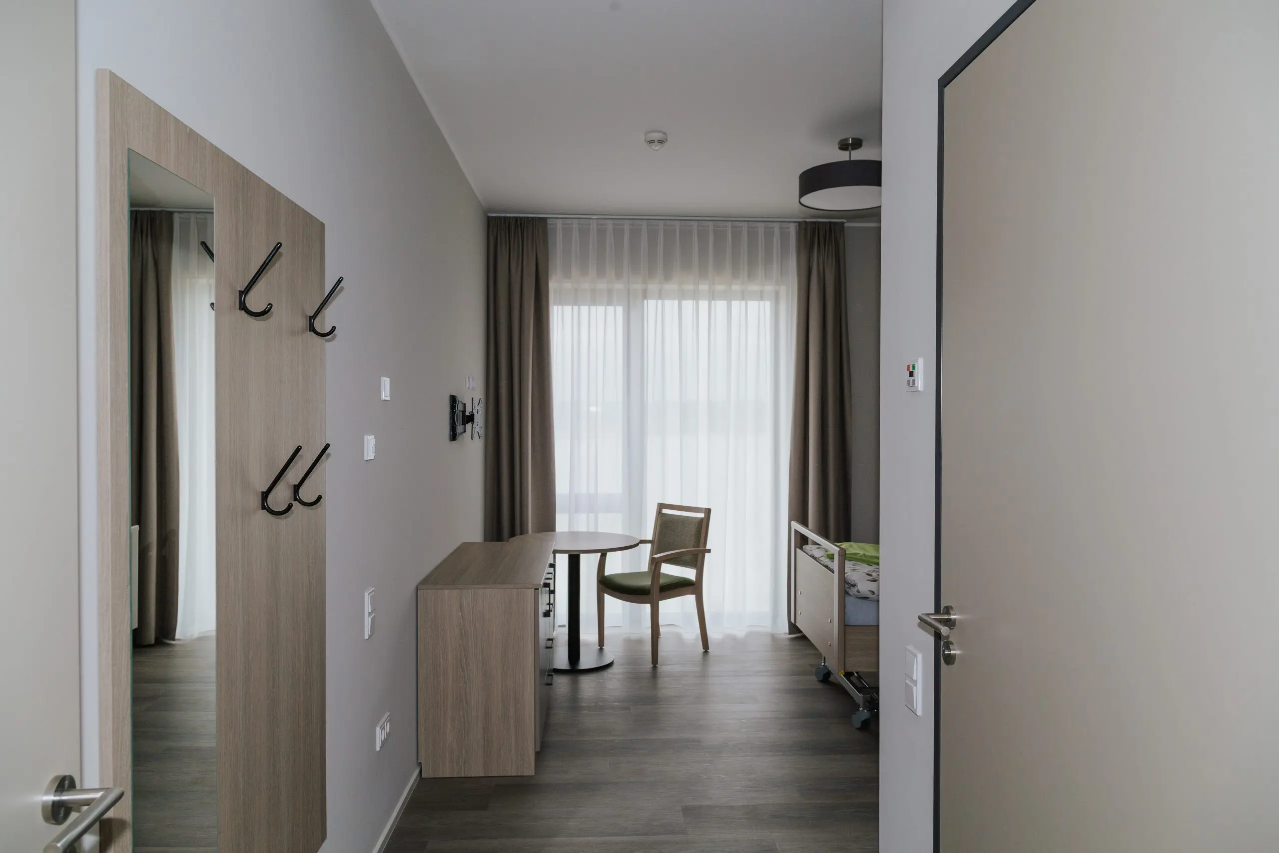 Pflegezimmer mit Garderobe und hellem Zugang im stationären Wohnen